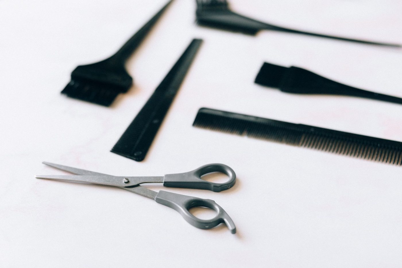Outils du barbier disposés à plat, ciseaux et peignes alignés sur le plan de travail du Cran